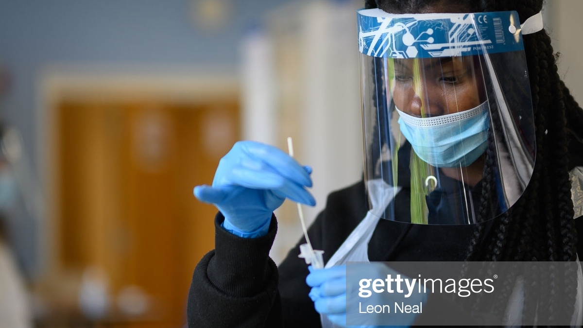 A woman processing a coronavirus swab test in PPE 